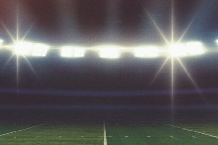 Football stadium lights shining over the field at night
